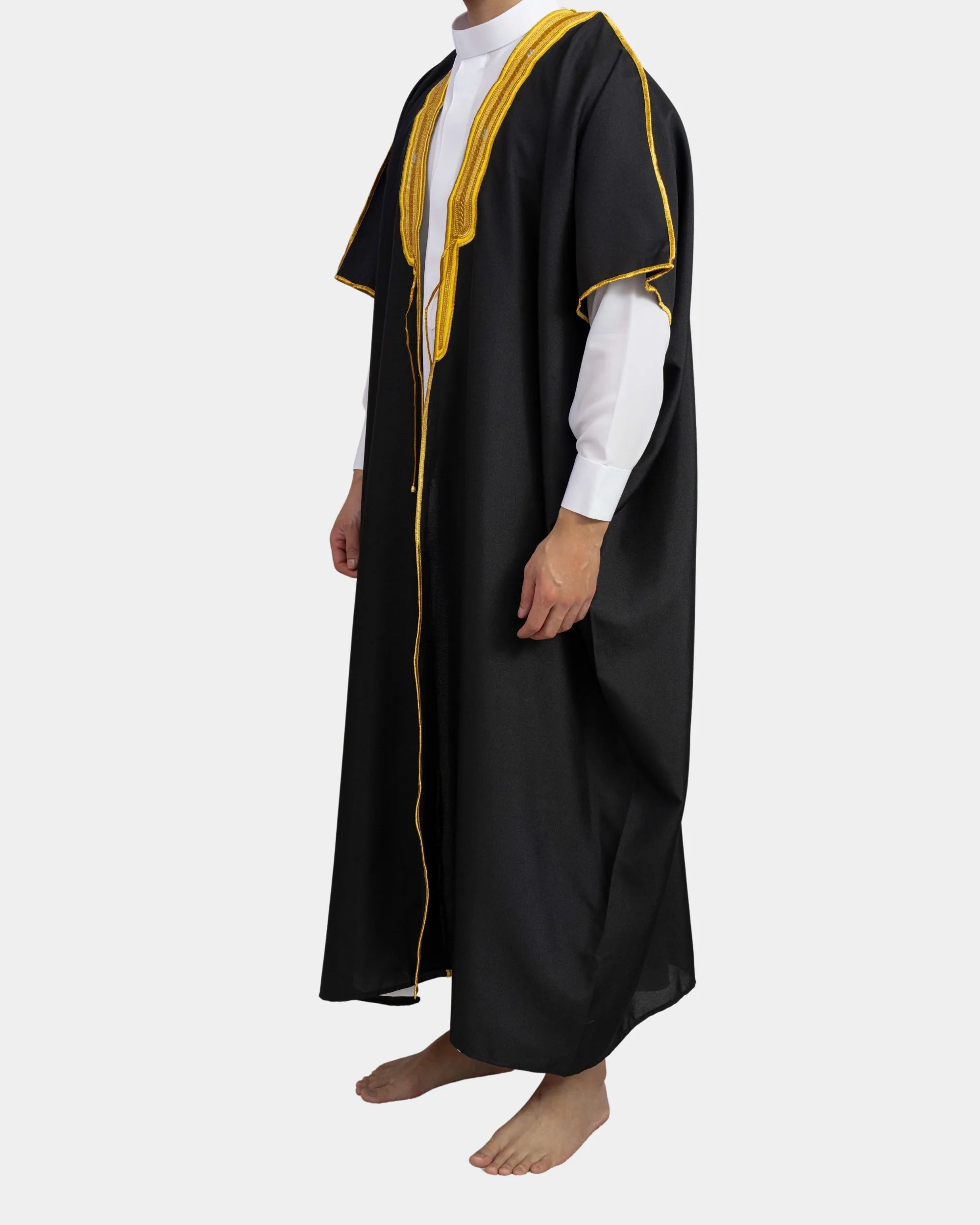 Bisht noir porté, liseré doré, vue de profil sur qamis blanc