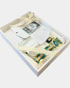 Coffret cadeau Omra et Hajj Al Rezam ouvert : ihram en coton blanc, ceinture ihram en cuir blanc et chechia blanche, présentés dans une boîte blanche nouée d'un ruban ivoire