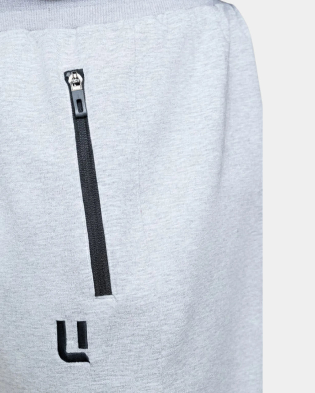Détail poche zippée et logo brodé du jogging sarouel gris chiné