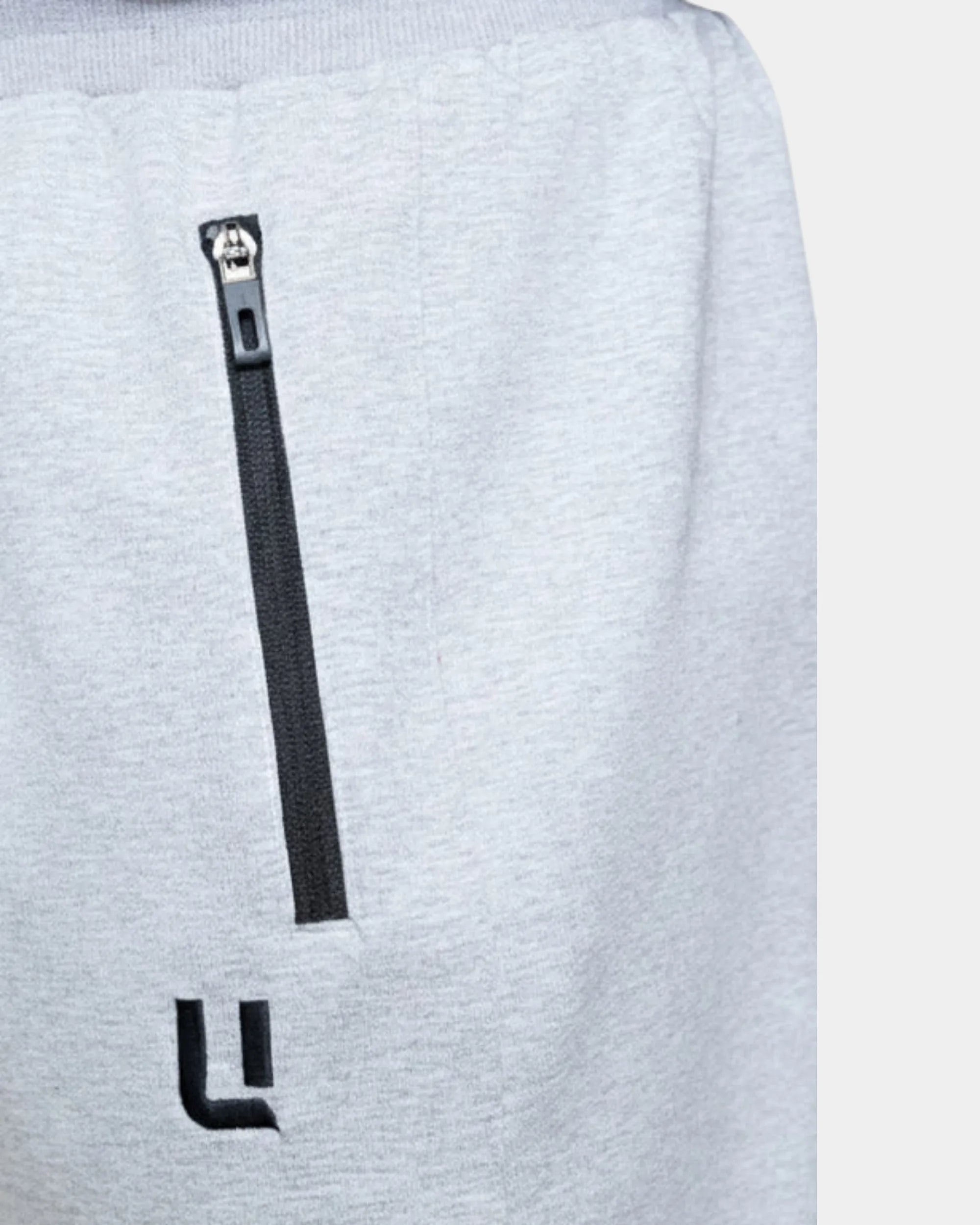 Détail poche zippée et logo brodé du jogging sarouel gris chiné