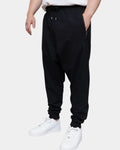 Jogging sarouel noir porté, coupe cousue basse, poche zippée latérale