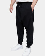 Jogging sarouel noir porté, coupe cousue basse, poche zippée latérale