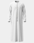 Qamis Dubaï blanc Al Rezam vu de face — col rond, empiècement surpiqué en V et gland tarbousha tressé