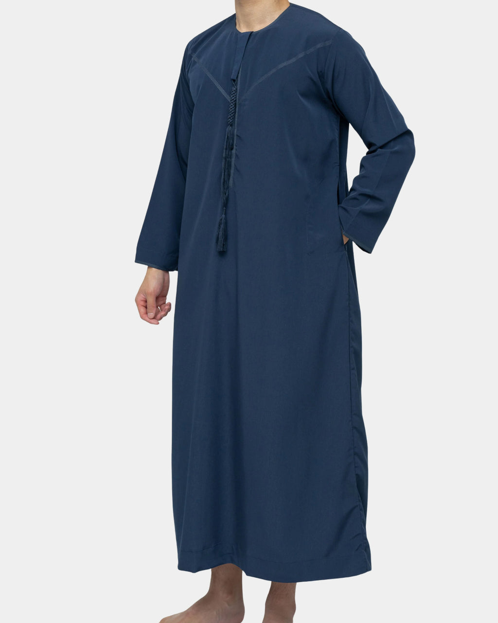 Qamis Dubaï bleu marine Al Rezam porté de profil — coupe droite fluide et gland tarbousha au col