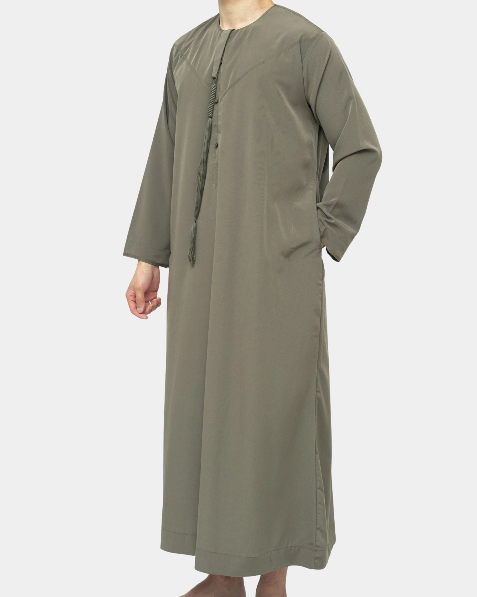 Qamis Dubaï kaki Al Rezam porté de profil — coupe droite fluide et gland tarbousha au col