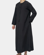 Détail du col rond et tarbousha tressé du qamis Dubaï noir Al Rezam