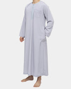 Qamis marocain gris Al Rezam porté de profil — tombé fluide, poches latérales et col rond brodé