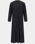 Qamis marocain noir Al Rezam vu de face — col rond brodé, plastron brodé sur le buste et poche poitrine assortie