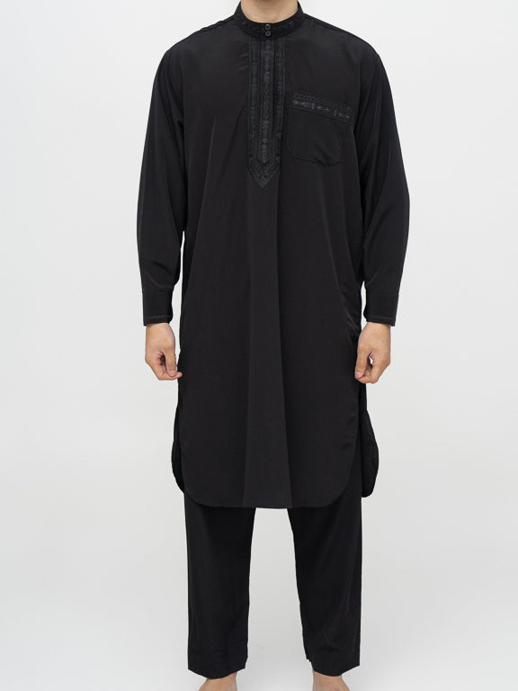 homme musulman portant un qamis pakistanais noir de face  