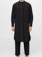 homme musulman portant un qamis pakistanais noir de face  