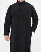 Qamis qatari noir Al Rezam porté de face, col chemise et poche poitrine