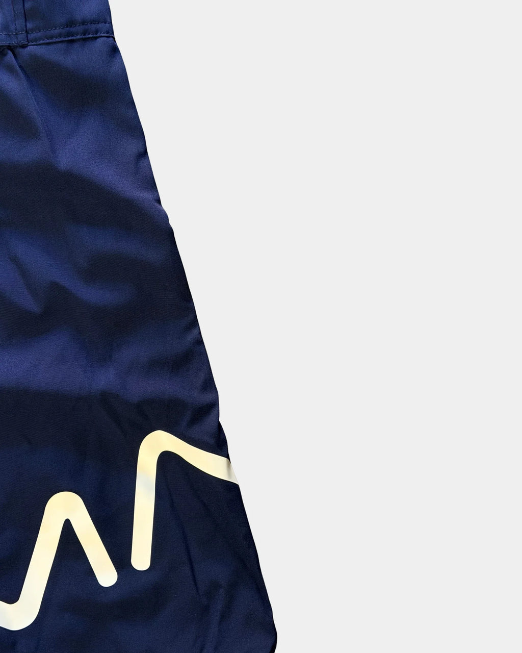 Détail du logo réfléchissant sur la jambe du short de bain awra bleu marine Al Rezam