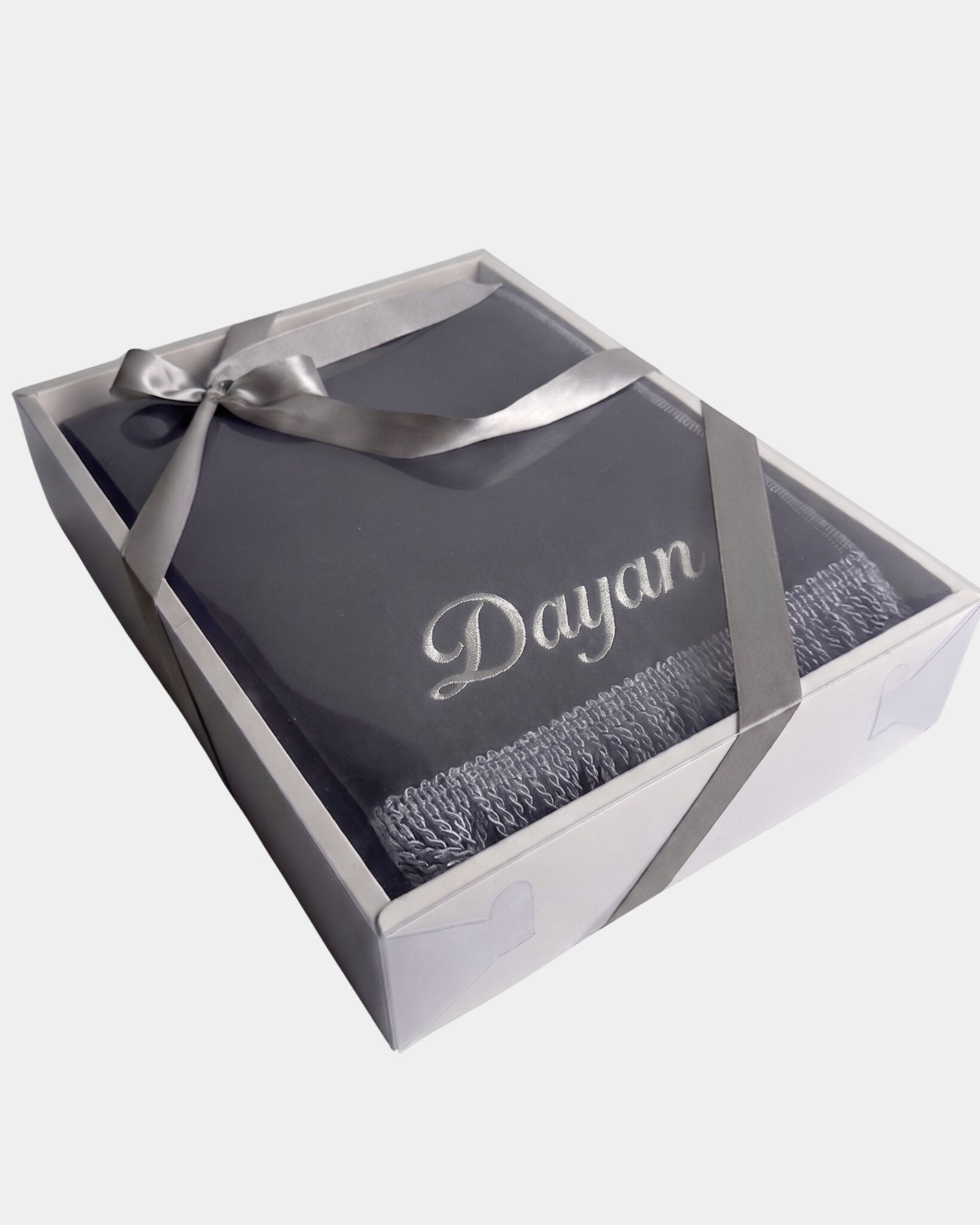Tapis de prière en velours gris anthracite avec le prénom Dayan brodé en fil argenté, présenté dans un coffret cadeau blanc noué d'un ruban gris assorti